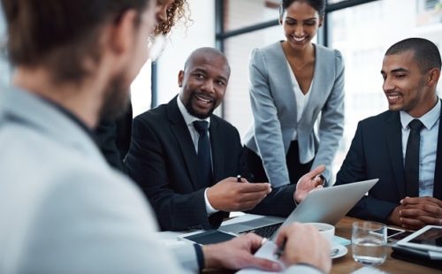Shot of a group of businesspeople discussing something on a laptop